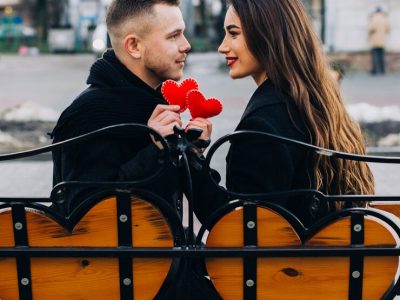 loving-couple-with-red-hearts-bench_23-2147735727